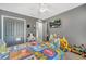 This bedroom features light gray walls, a ceiling fan, and a TV at 5640 Silver Thistle Ln, St Cloud, FL 34772