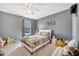 bedroom features a ceiling fan, modern gray walls, and playful decor at 5640 Silver Thistle Ln, St Cloud, FL 34772