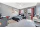 This bedroom is decorated with a black bed frame, windows, dark grey walls, and ceiling fan at 5640 Silver Thistle Ln, St Cloud, FL 34772