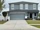 Charming two-story home with a well-manicured lawn and a spacious driveway leading to a two-car garage at 5640 Silver Thistle Ln, St Cloud, FL 34772