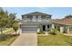 Charming two-story home with a well-maintained lawn, lush landscaping, and a spacious two car garage at 5640 Silver Thistle Ln, St Cloud, FL 34772
