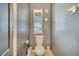 Well-lit powder room with white toilet and a window with blinds for natural light at 5640 Silver Thistle Ln, St Cloud, FL 34772