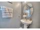 Cozy powder room with pedestal sink, decorative mirror, and a neutral color scheme at 5640 Silver Thistle Ln, St Cloud, FL 34772