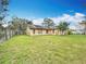 Backyard featuring a grassy lawn and mature trees providing shade and privacy at 707 Divot Ln, Poinciana, FL 34759