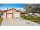 Charming single-story home featuring a well-manicured lawn and a spacious driveway leading to an attached garage at 707 Divot Ln, Poinciana, FL 34759