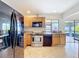 Functional kitchen with stainless steel appliances and a view to the backyard through the window over the sink at 707 Divot Ln, Poinciana, FL 34759