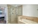 Bright bathroom featuring a glass shower, soaking tub, and neutral tile throughout at 7602 Cabana Ct # 101, Reunion, FL 34747