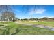 Scenic view of the well-manicured golf course with lush green grass and sand traps under a blue sky at 7602 Cabana Ct # 101, Reunion, FL 34747