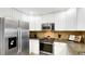 Bright kitchen featuring stainless steel appliances, granite countertops and white cabinetry at 7602 Cabana Ct # 101, Reunion, FL 34747