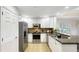 Modern kitchen features stainless steel appliances, granite countertops, and white cabinets at 7602 Cabana Ct # 101, Reunion, FL 34747