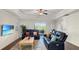 Bright living room with ceiling fan, plantation shutters, and sliding door access to the lanai at 7602 Cabana Ct # 101, Reunion, FL 34747