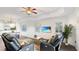 Well-lit living room with open access to the dining and kitchen areas, ceiling fan, and television at 7602 Cabana Ct # 101, Reunion, FL 34747