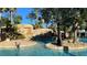 Beautiful pool area featuring palm trees, rock features, and clear, refreshing water at 7602 Cabana Ct # 101, Reunion, FL 34747