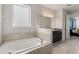 Luxurious bathroom featuring a soaking tub, tiled accents, and contemporary fixtures at 7649 Wilmington Loop, Kissimmee, FL 34747