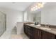 Bright bathroom featuring a double vanity with granite countertop, a glass-enclosed shower, and tiled floors at 7649 Wilmington Loop, Kissimmee, FL 34747