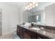 Modern bathroom featuring dual vanities, granite counters, and a glass-enclosed shower at 7649 Wilmington Loop, Kissimmee, FL 34747