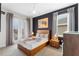 Modern bedroom featuring a bamboo bedframe with indigo accent wall and large windows at 7649 Wilmington Loop, Kissimmee, FL 34747