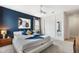 Bedroom featuring a modern bedframe with bold blue accent wall and abstract art at 7649 Wilmington Loop, Kissimmee, FL 34747