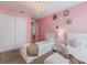 Lovely pink bedroom featuring twin beds, closet and stylish decor at 7649 Wilmington Loop, Kissimmee, FL 34747