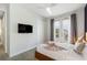 A cozy bedroom with a queen-size bed, mounted TV, and lots of natural light at 7649 Wilmington Loop, Kissimmee, FL 34747
