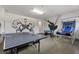 Spacious game room complete with ping pong table, foosball table, and vibrant superhero-themed wall art at 7649 Wilmington Loop, Kissimmee, FL 34747