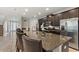 Modern kitchen featuring dark cabinets, granite countertops, stainless steel appliances, and a large central island at 7649 Wilmington Loop, Kissimmee, FL 34747
