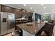 Modern kitchen featuring dark cabinets, stainless steel appliances, granite countertops, and an island with seating at 7649 Wilmington Loop, Kissimmee, FL 34747