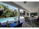Inviting covered patio area with an outdoor dining set, pool, and lush tropical landscaping at 7649 Wilmington Loop, Kissimmee, FL 34747