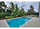 Relax and unwind in this stunning backyard pool with integrated jacuzzi and lush tropical landscaping for privacy at 7649 Wilmington Loop, Kissimmee, FL 34747