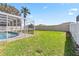 Spacious backyard featuring a private pool area, green lawn, and privacy fence at 7706 Water Oak Ct, Kissimmee, FL 34747
