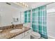 Well-lit bathroom featuring granite countertop, white cabinets, and a shower with a turquoise curtain at 7706 Water Oak Ct, Kissimmee, FL 34747