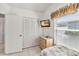 Bright bedroom with a large window, TV, tile flooring, and ample closet space at 7706 Water Oak Ct, Kissimmee, FL 34747