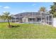 A beautiful screened-in pool with backyard and green grass at 7706 Water Oak Ct, Kissimmee, FL 34747
