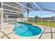 Private pool area with screened enclosure and well-manicured lawn with palm trees at 7706 Water Oak Ct, Kissimmee, FL 34747