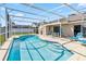 Sparkling blue pool surrounded by a screened enclosure and a spacious outdoor patio at 7706 Water Oak Ct, Kissimmee, FL 34747