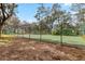 Community tennis court with green fence and shade at 7706 Water Oak Ct, Kissimmee, FL 34747