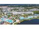 Aerial view showcasing the resort's pools, waterslides, entertainment, and surrounding lush greenery and lakes at 8029 Sandy Toes Way, Kissimmee, FL 34747