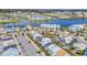 A scenic aerial view of colorful homes by a lake, featuring community pools and parking at 8029 Sandy Toes Way, Kissimmee, FL 34747