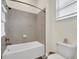 Bathroom with a clean white bathtub and shower combo featuring gray tile surround at 8029 Sandy Toes Way, Kissimmee, FL 34747