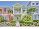Charming two-story green home with a balcony, complemented by lush landscaping at 8029 Sandy Toes Way, Kissimmee, FL 34747
