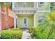 Close-up of a charming green home's entrance with landscaped garden, enhancing curb appeal at 8029 Sandy Toes Way, Kissimmee, FL 34747
