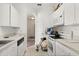 Galley kitchen with white cabinets and appliances, featuring an arched doorway at 8103 Coconut Palm Way # 204, Kissimmee, FL 34747