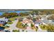 Aerial view of home with a brown roof near a lake, complete with mature trees and green landscaping at 919 Lake Charles Dr, Davenport, FL 33837