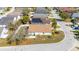An aerial view of a home with a brown roof, white fence, and mature trees in a residential neighborhood at 919 Lake Charles Dr, Davenport, FL 33837