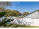 A serene backyard view with a white fence, lush green grass, and a glimpse of the lake at 919 Lake Charles Dr, Davenport, FL 33837