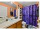 Colorful bathroom features a toilet and a shower with a curtain at 919 Lake Charles Dr, Davenport, FL 33837