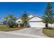 Front exterior of house boasting manicured landscaping, shade trees, and a paved driveway at 919 Lake Charles Dr, Davenport, FL 33837