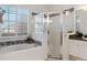 Bright bathroom features a shower and soaking tub with tiled walls and a decorative border at 993 Everest, Clermont, FL 34711