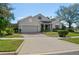 Inviting one-story home with a brick driveway, manicured lawn, and lovely front yard landscaping at 993 Everest, Clermont, FL 34711