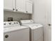 Functional laundry room area featuring a white washer and dryer, and overhead cabinets for storage at 993 Everest, Clermont, FL 34711